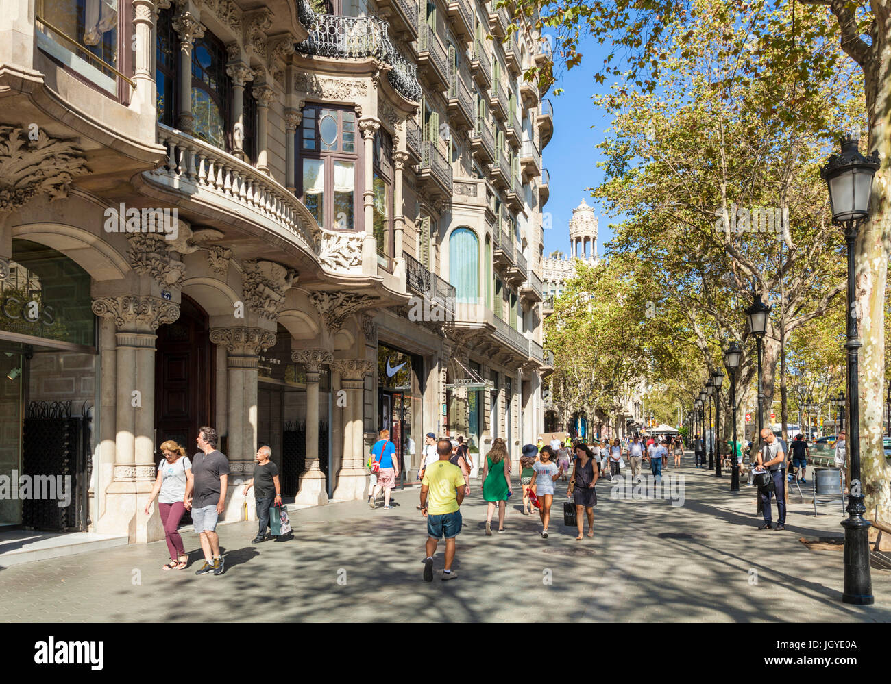 Barcelone Catalogne Espagne touristes marcher le long de la bordée d'arbres rue principale Passeig de Gracia de Barcelone Catalogne europe ue avenue Banque D'Images