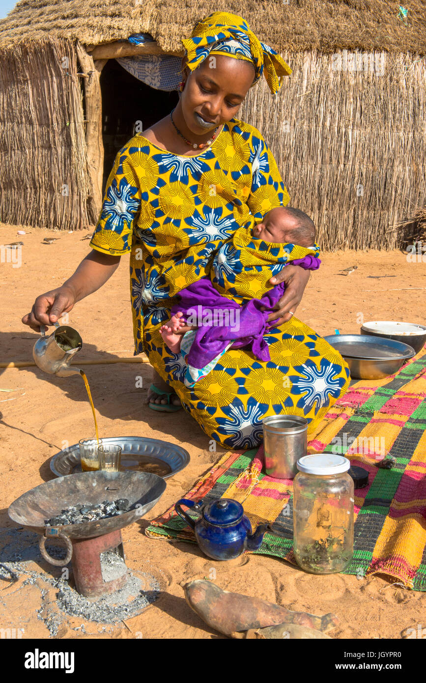 Jeune mère de verser le thé. Le Sénégal. Banque D'Images