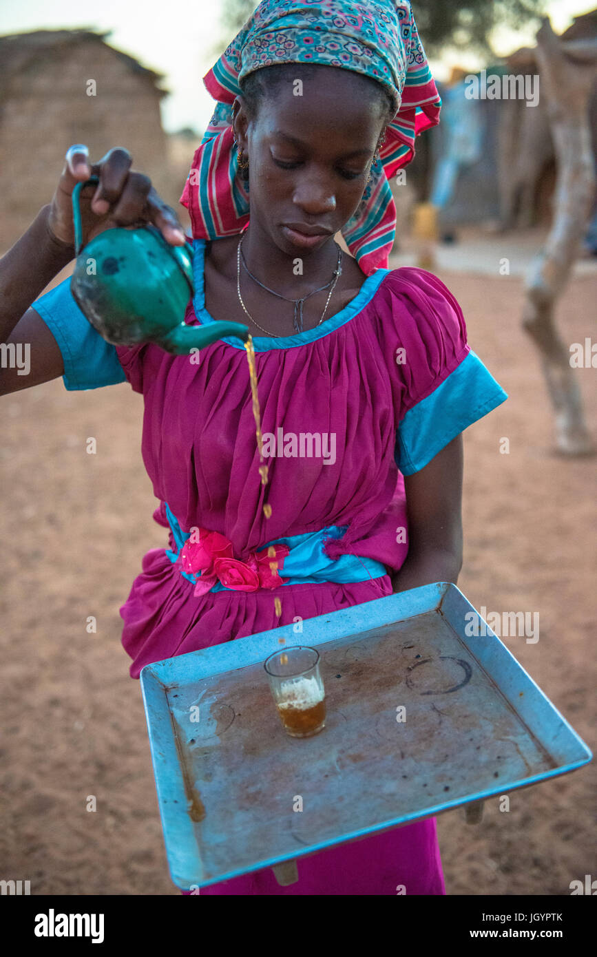 Fille Peul servir le thé. Le Sénégal. Banque D'Images