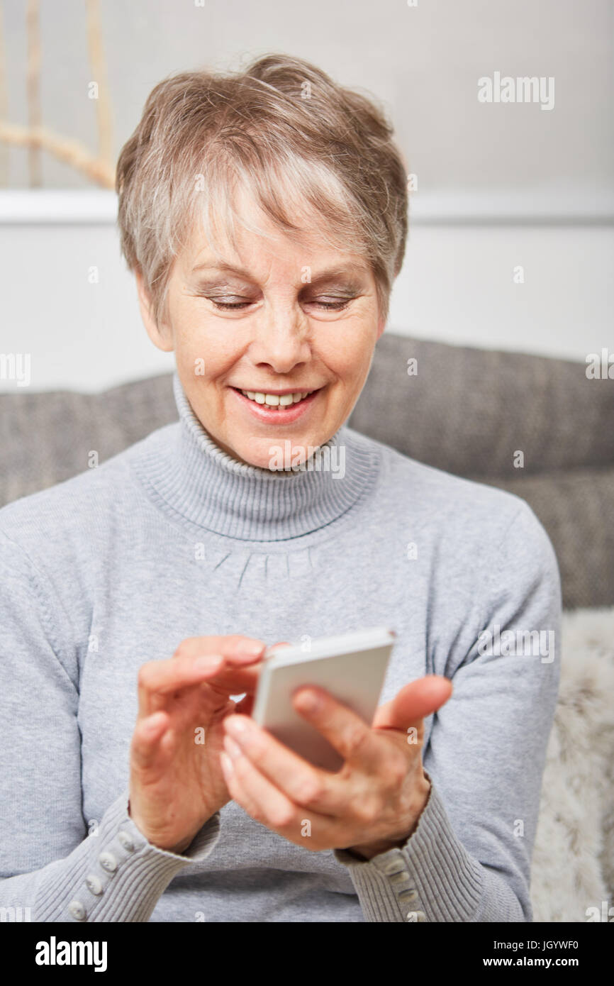 Senior woman using smartphone pour chat et écrire un message Banque D'Images