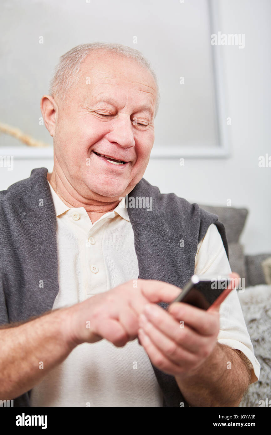 Senior citizen écrit un message ou SMS avec son smartphone Banque D'Images