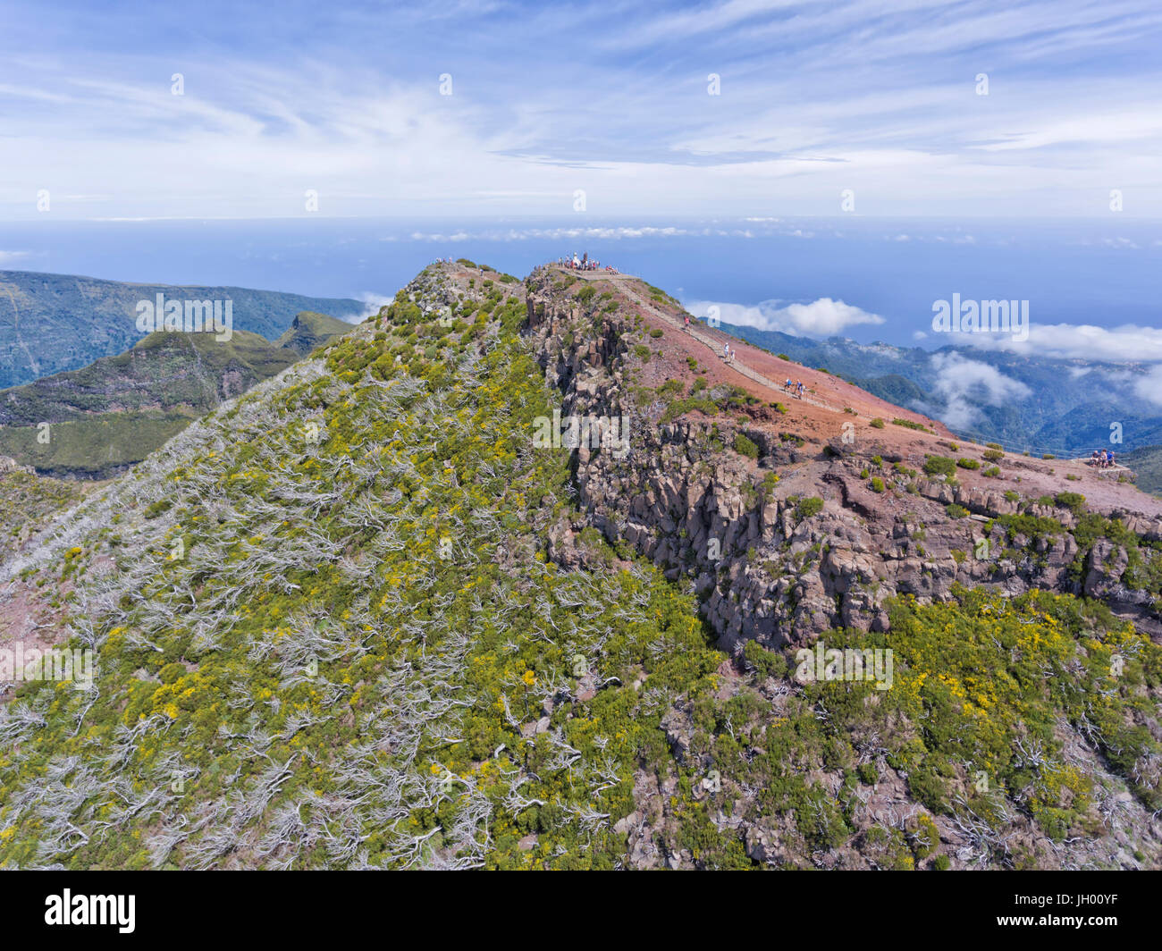 Vue aérienne du plus haut sommet de l'île de Madère, Pico Ruivo, des randonneurs sur un sentier de randonnée vers le haut et les nuages bas dans la vallée . Banque D'Images