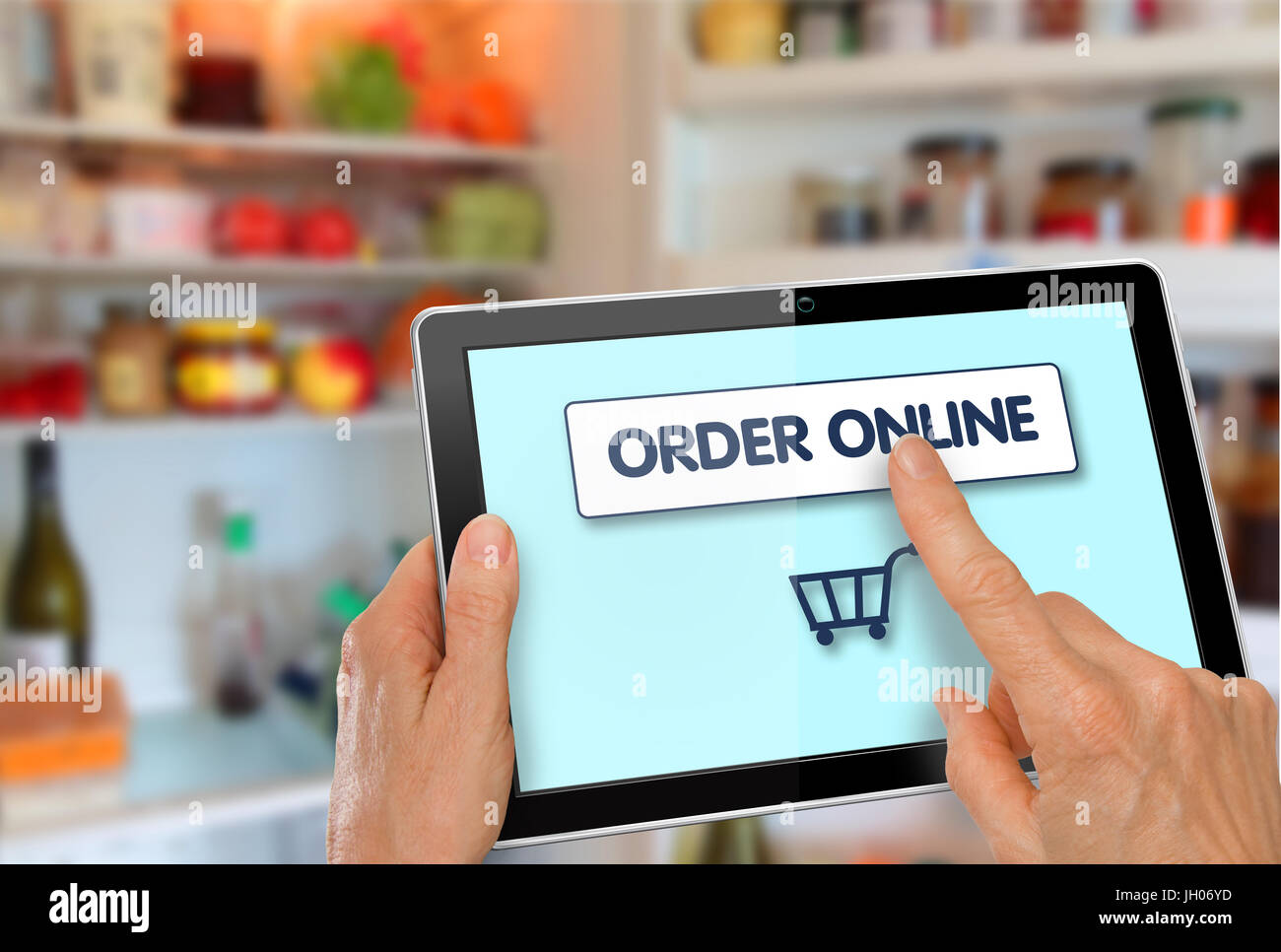 Supermarché en ligne Shopping mains avec tablette ordinateur icône panier à l'avant du réfrigérateur Banque D'Images