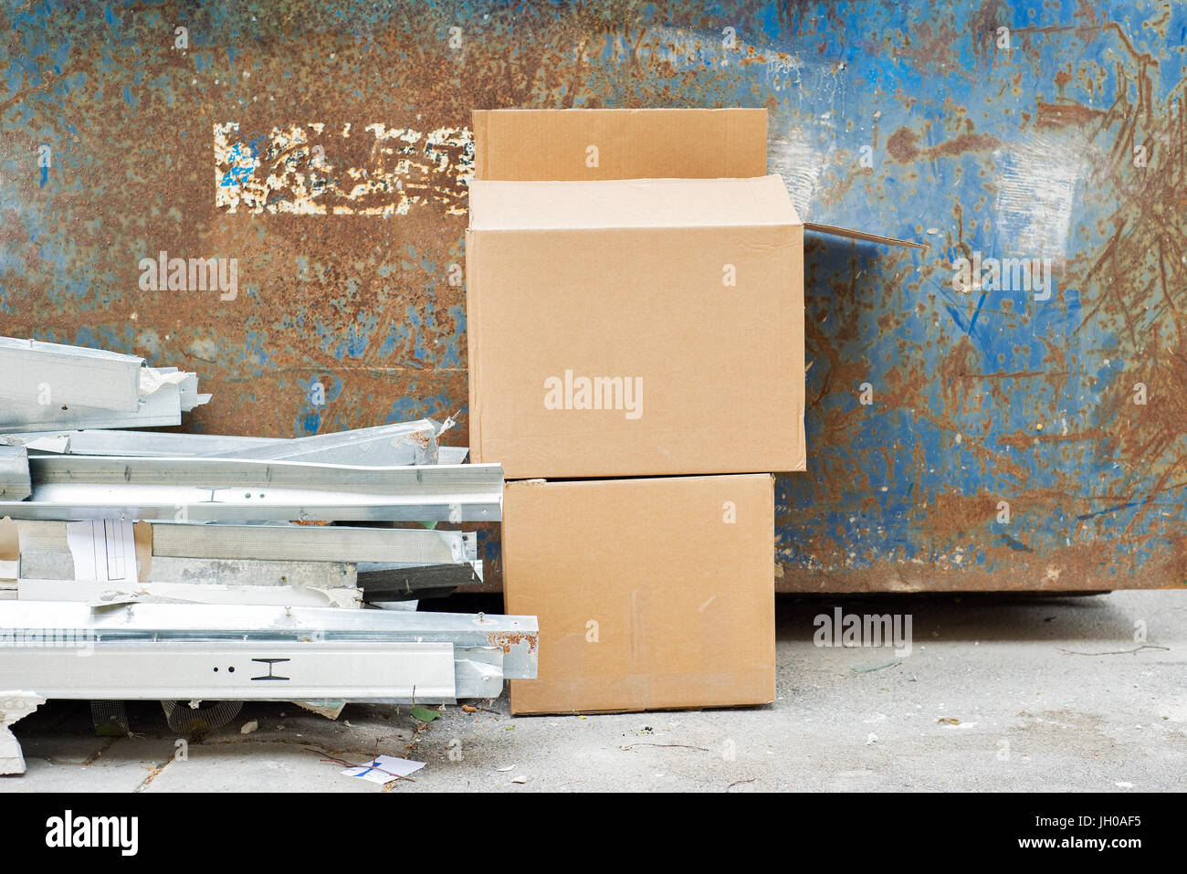 Déchets de construction près de la poubelle en métal Banque D'Images