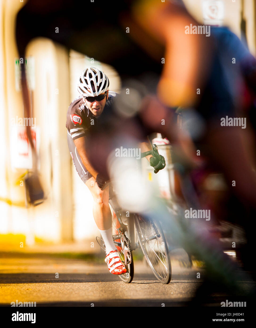 Un jeune homme athlétique en compétition cycliste en milieu urbain course sur route. Banque D'Images