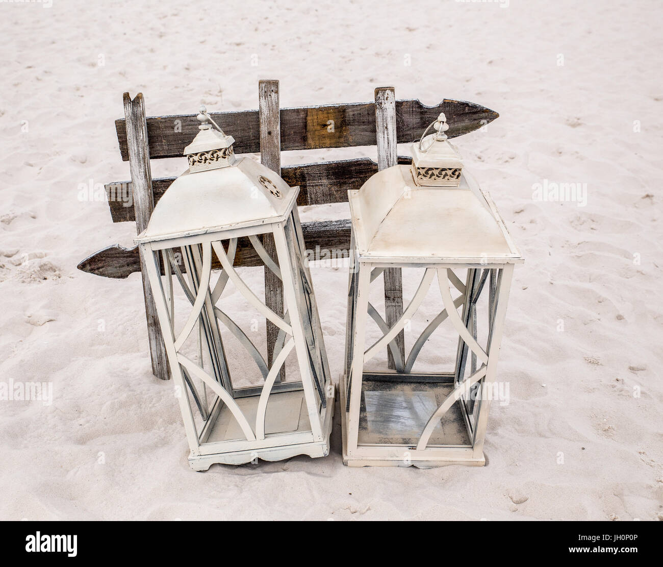 Cette photo montre métal blanc rustique ouverte à pans de maisons lanterne associés en face de sélection des flèches sur la plage. Banque D'Images