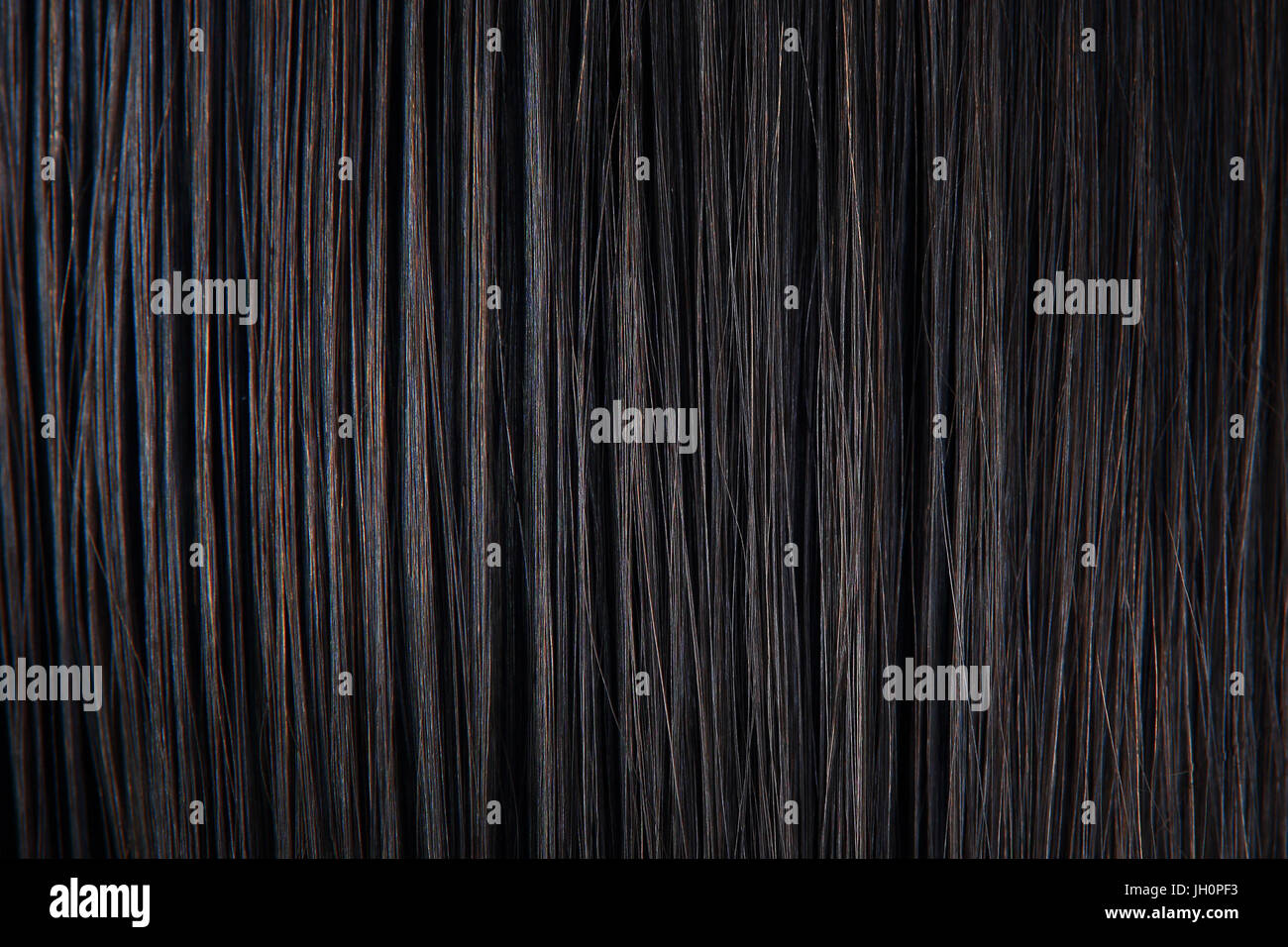 Cheveux noir droit close-up. La texture de cheveux femme sombre. Arrière-plan de cheveux des femmes noires. Banque D'Images