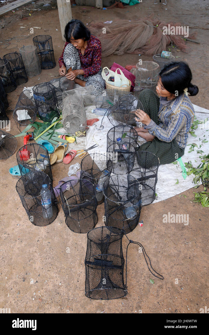 Les clients de la microfinance AMK la réparation du matériel de pêche. Le Cambodge. Banque D'Images