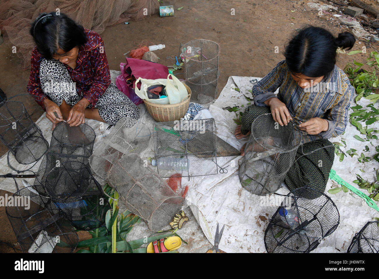 Les clients de la microfinance AMK la réparation du matériel de pêche. Le Cambodge. Banque D'Images