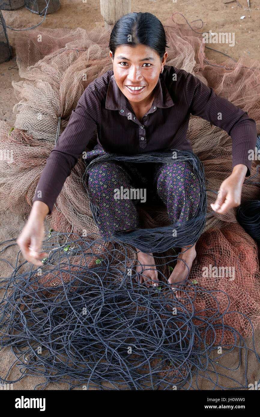 Client de la microfinance AMK Chanty beaucoup la réparation du matériel de pêche. Le Cambodge. Banque D'Images