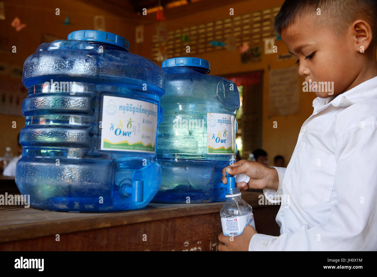 Enfant dans une école avec de l'eau potable grâce à 1001 Fontaines. Le Cambodge. Banque D'Images