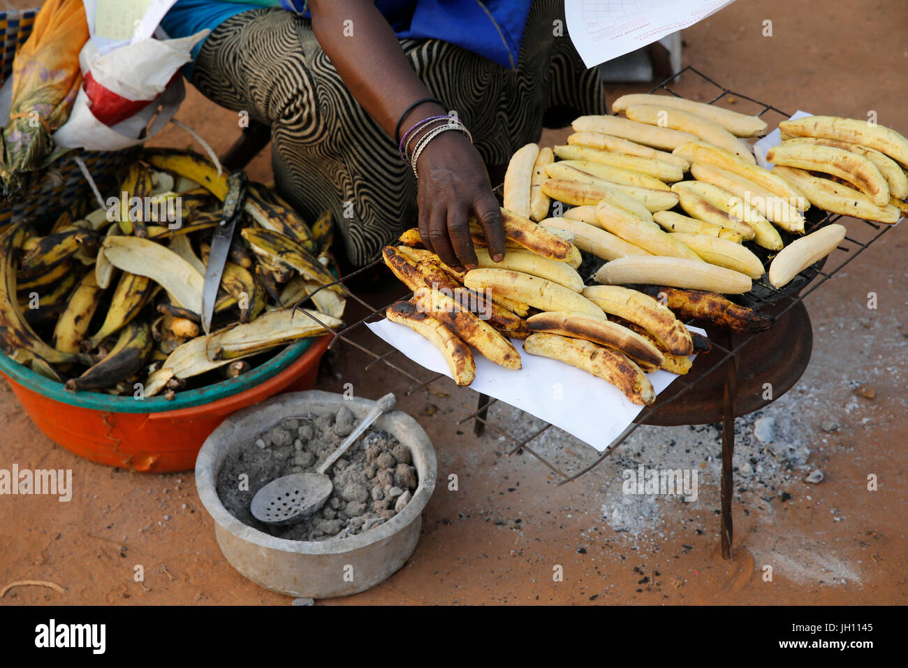 Femme faire et vendre en plantain grillé. Mulago L'Ouganda. Banque D'Images