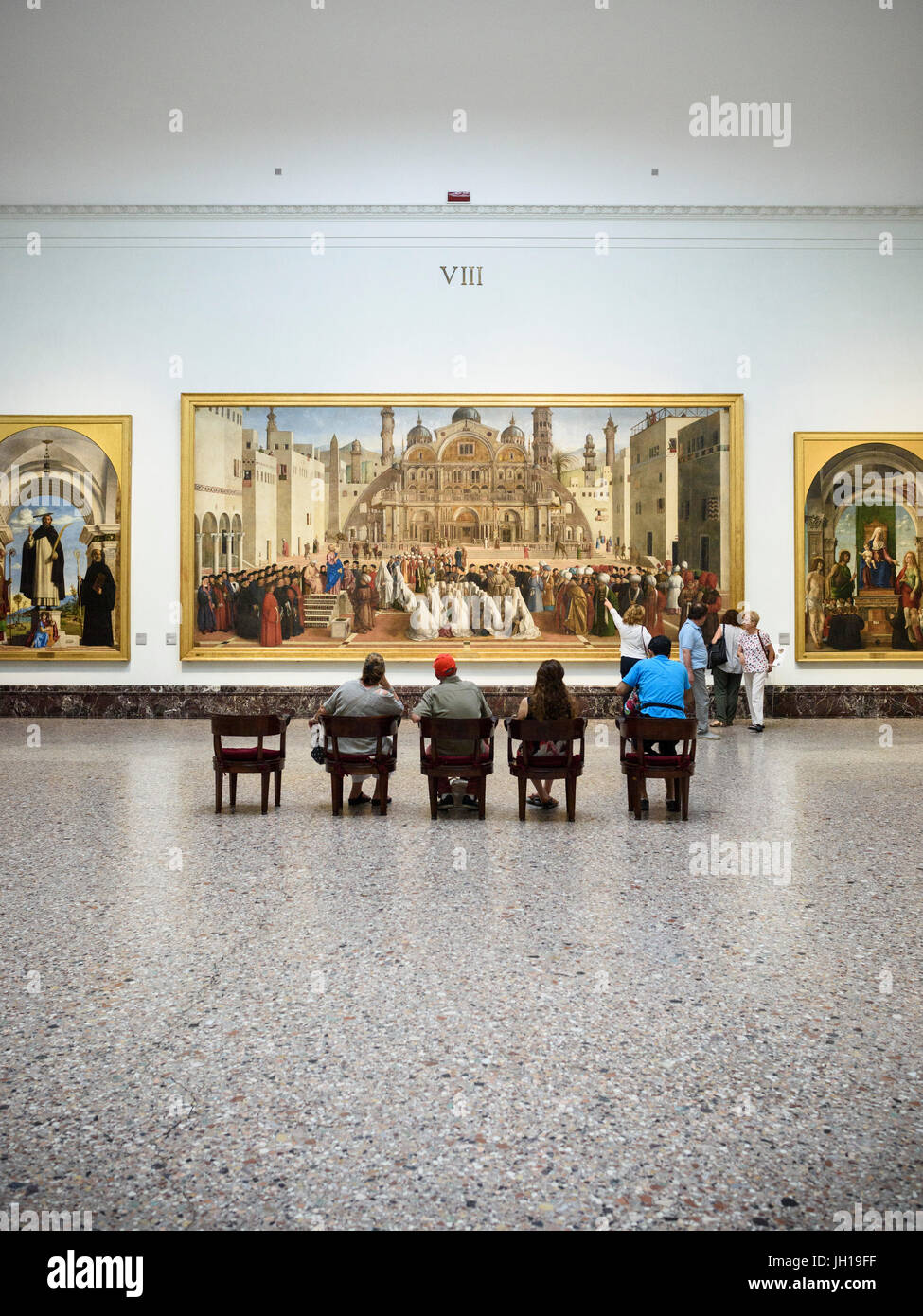 Milan. L'Italie. Visiteurs à la Pinacoteca di Brera, à la peinture à l''St. Mark prêchant dans Alexandria', 1504-7, par Gentile e Giovanni Bellini. Banque D'Images