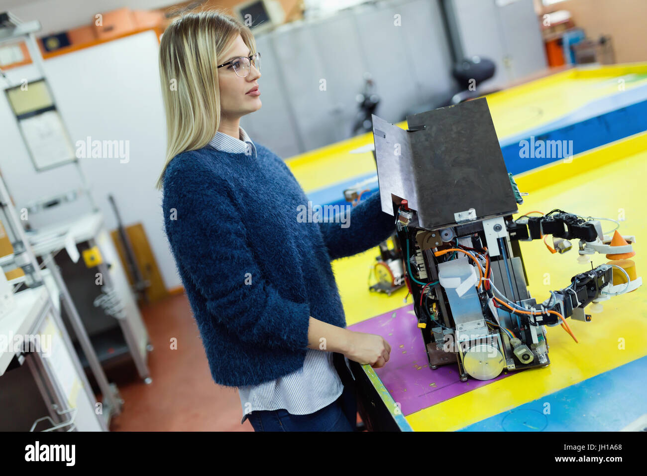 Belle jeune femme robot test ingénieur en atelier Banque D'Images