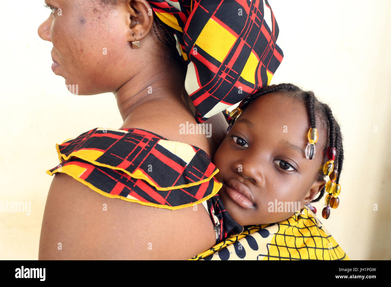 Jeune fille africaine réalisées sur le dos de sa mère. Le Togo. Banque D'Images