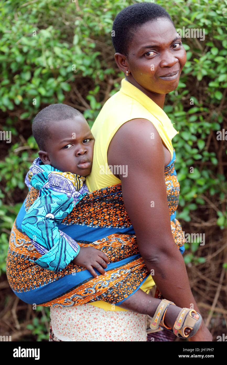 Bébé africain réalisé sur le dos de sa mère. Le Togo. Banque D'Images