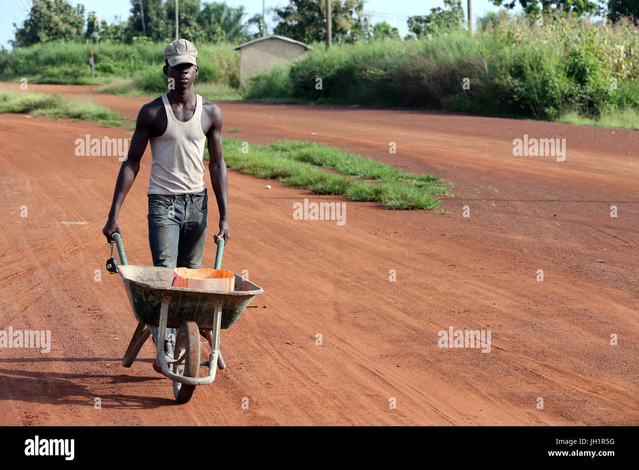 Worker pushing wheelbarrow. Le Togo. Banque D'Images