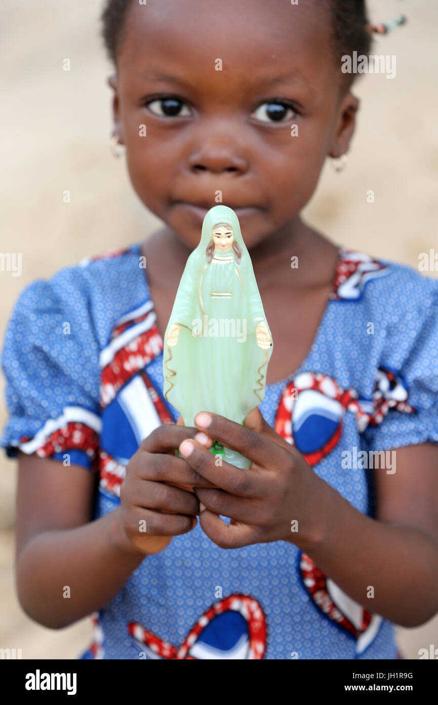 African girl holding Vierge Marie statue. Lome. Le Togo. Banque D'Images