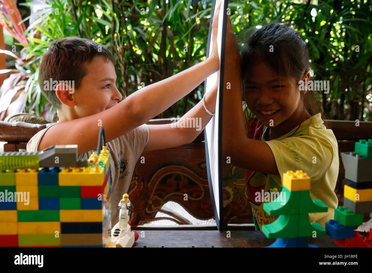 Garçon et fille jouant avec un rebond. La Thaïlande. Banque D'Images