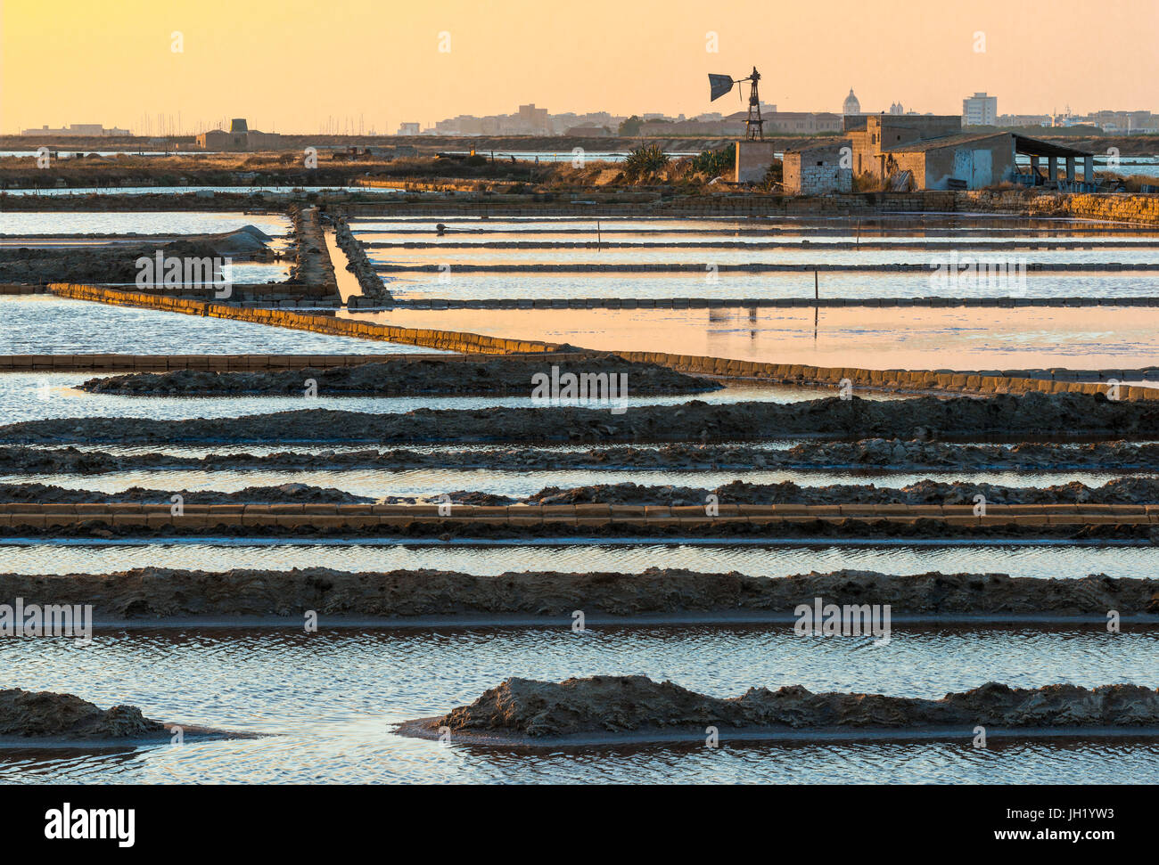Coucher du soleil sur le sel et les moulins à vent de la faune à la réserve près de la Nubie, au sud de Trapani, sur la côte ouest de la Sicile, en Italie. Banque D'Images