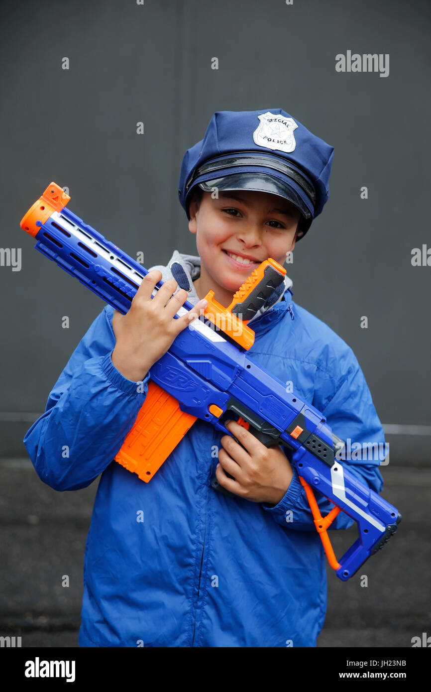 Garçon de 10 ans portant un chapeau de policier et tenant une arme-jouet. La France. Banque D'Images