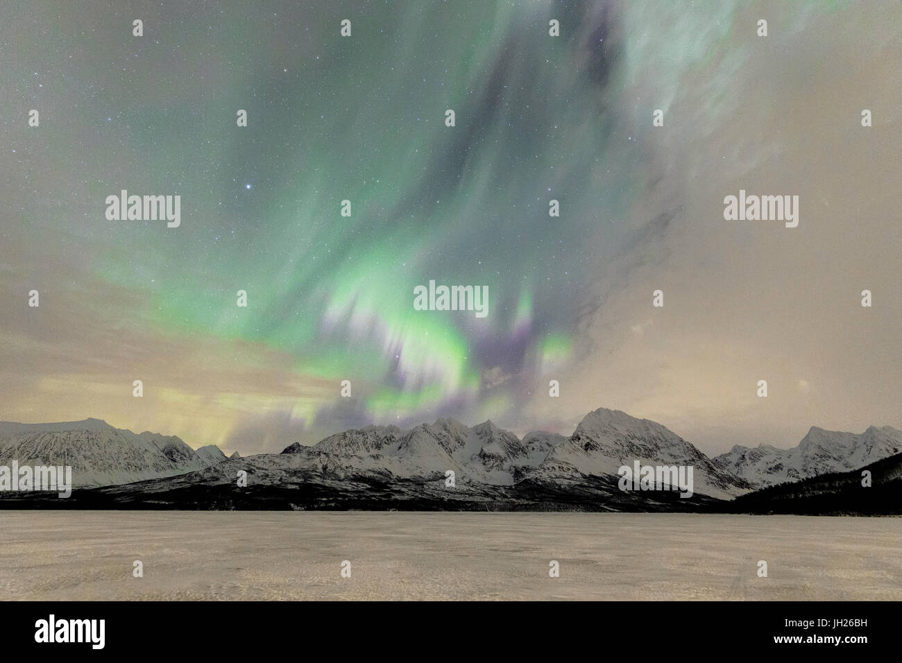Le lac glacé de Jaegervatnet encadrée par la Northern Lights et ciel étoilé dans la nuit polaire, Alpes de Lyngen, Troms, Norvège Banque D'Images