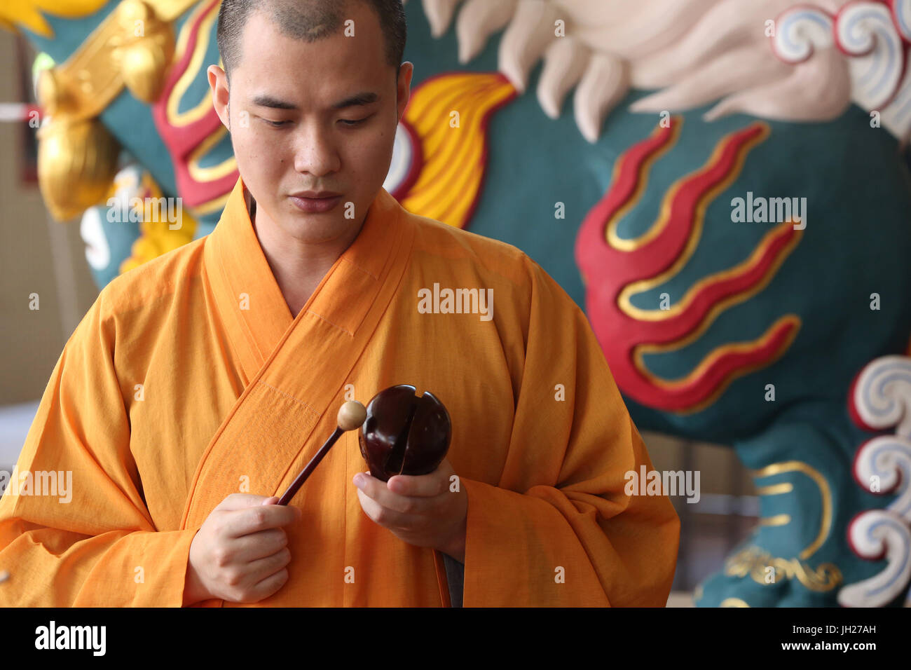 Kong Meng San Phor Kark Voir le monastère. Monk jouant sur un poisson en bois (instrument à percussion). Singapour. Banque D'Images