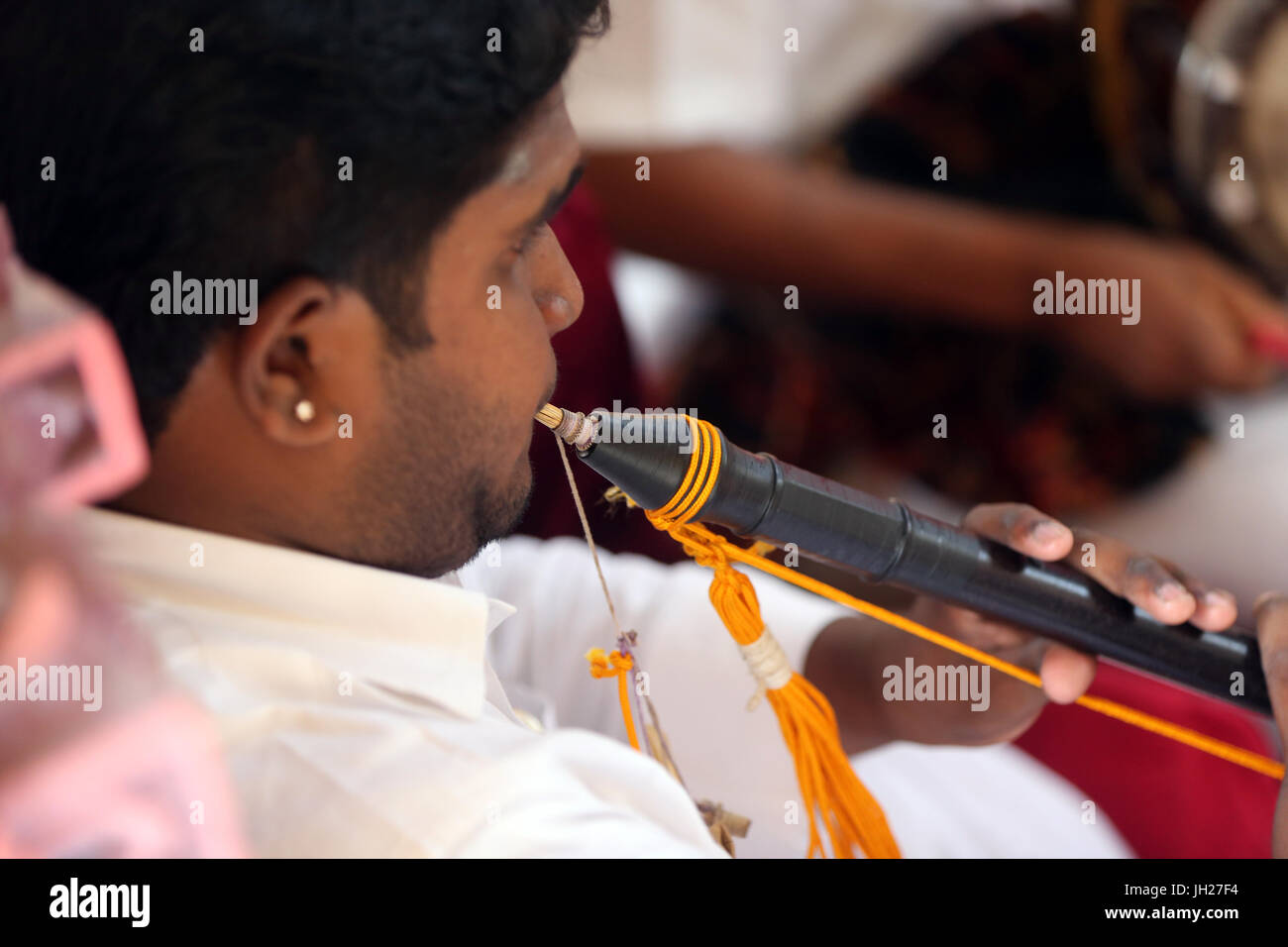 Musicien jouant de la flûte au cours d'une cérémonie traditionnelle hindoue. Sri Mariamman temple hindou. Singapour. Banque D'Images