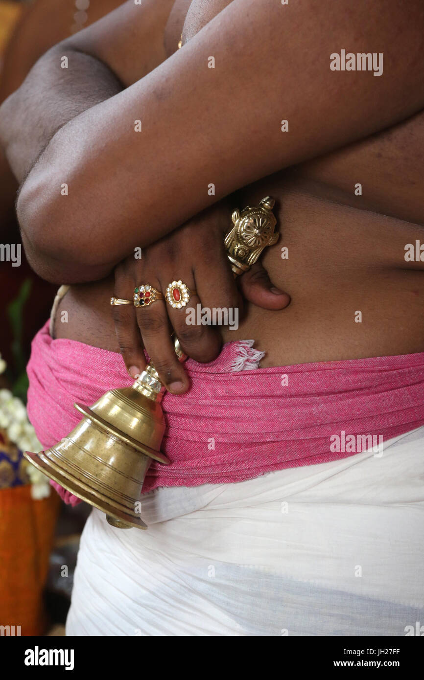 Prêtre hindou. Close up of hand holding bell de cérémonie. Singapour. Banque D'Images