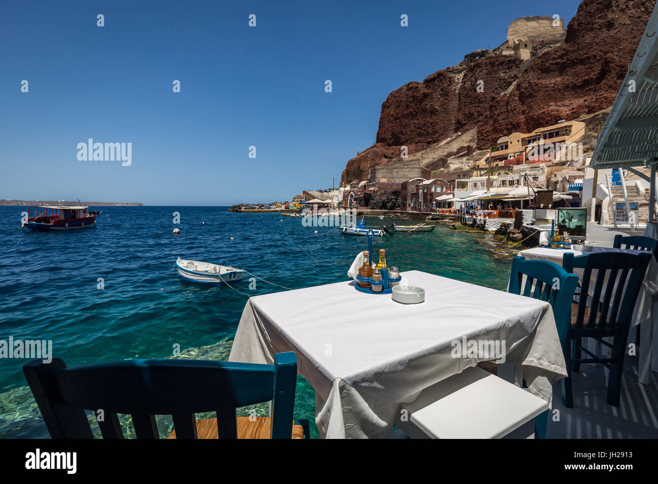Une table avec vue sur l'un des restaurants de fruits de mer dans la baie d'Ammoudi ci-dessous, Oia, Santorin, Cyclades, îles grecques, Grèce Banque D'Images