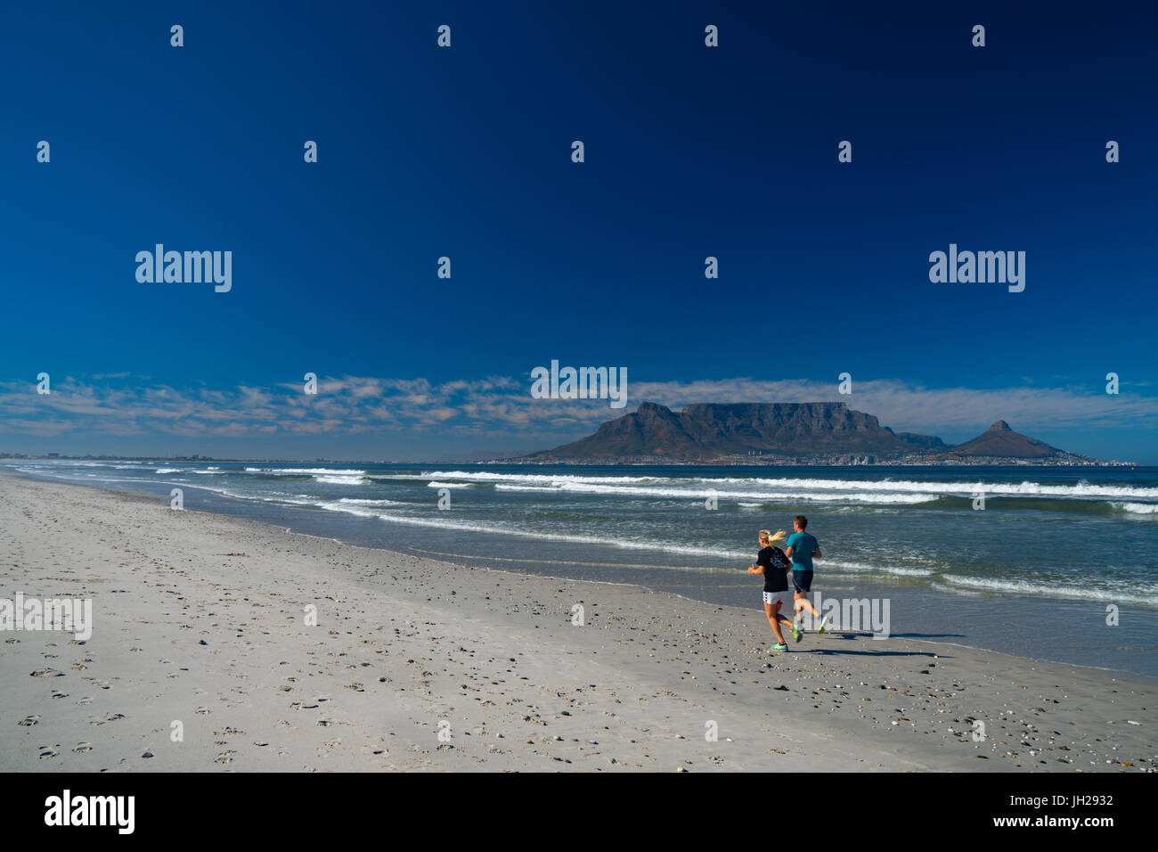 Les coureurs s'exécutant sur la plage de Blouberg, tôt le matin, avec la Montagne de la table en arrière-plan, Le Cap, Afrique du Sud, l'Afrique Banque D'Images