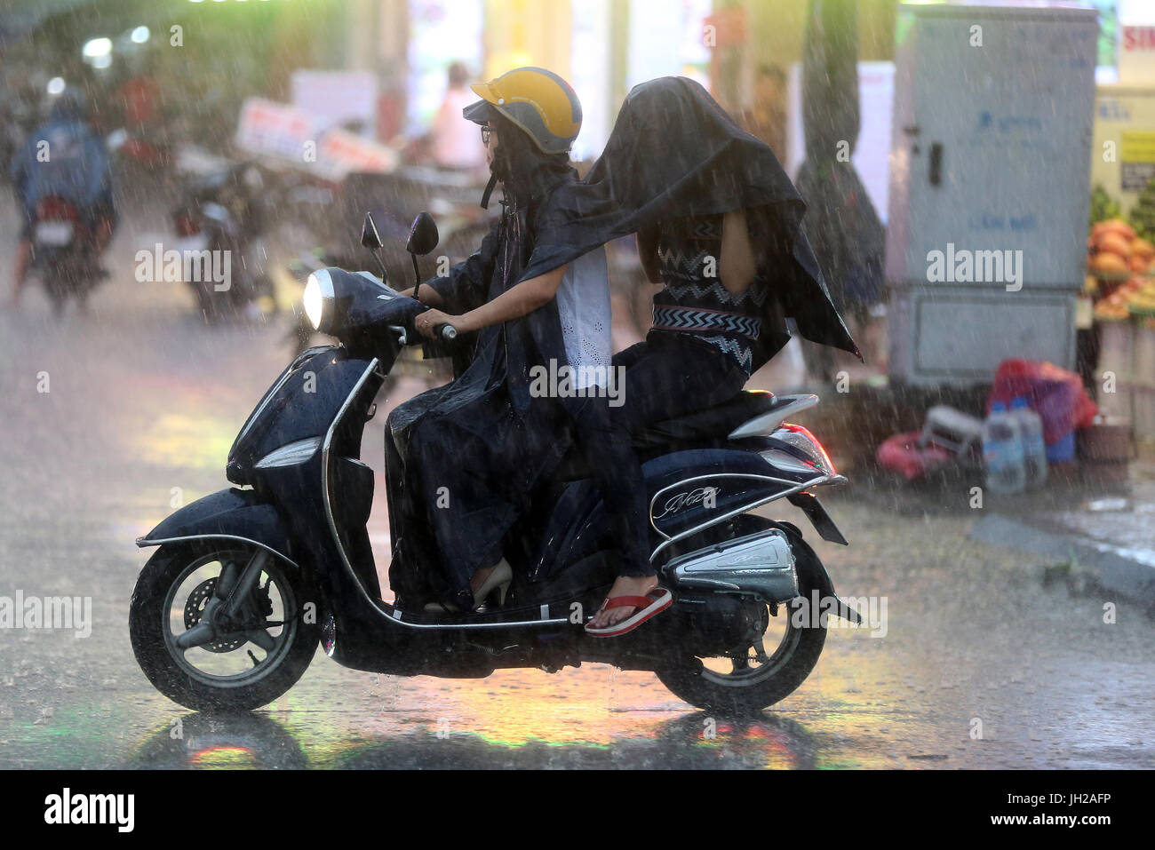 De fortes pluies de mousson. Scooter sur Saigon Street. Le Vietnam. Banque D'Images