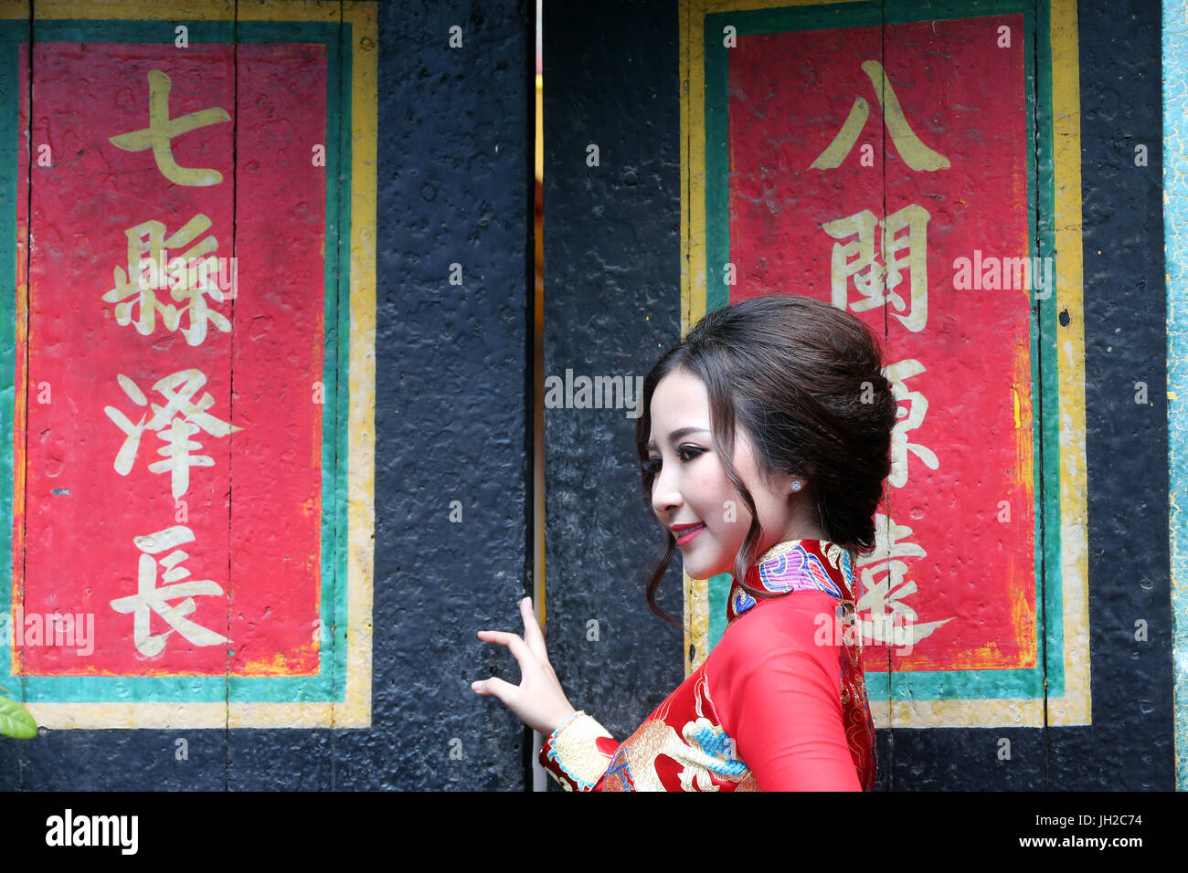 Temple taoïste. Une pagode de Phuoc Hoi Quan. Femme portant une robe traditionnelle du Vietnam appelé Ao Dai. Le temple taoïste Chua Lang. Ho Chi Minh Ville. Le Vietnam. Banque D'Images