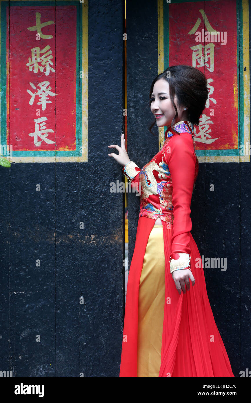Temple taoïste. Une pagode de Phuoc Hoi Quan. Femme portant une robe traditionnelle du Vietnam appelé Ao Dai. Le temple taoïste Chua Lang. Ho Chi Minh Ville. Le Vietnam. Banque D'Images