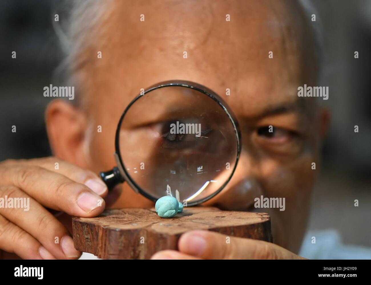 Taipei, Taiwan. 12 juillet, 2017. Chen Fengxian, une sculpture artiste, regarde sa sculpture miniature à Taipei, Taiwan de la Chine du sud-est, le 12 juillet 2017. Chen a travaillé sur la sculpture miniature pendant plus de 30 ans, la sculpture avec des matériaux tels que le riz, l'or et le bois. Les sculptures miniatures il fait peut même se tenir sur la tête d'une épingle. Credit : Zhou Mi/Xinhua/Alamy Live News Banque D'Images