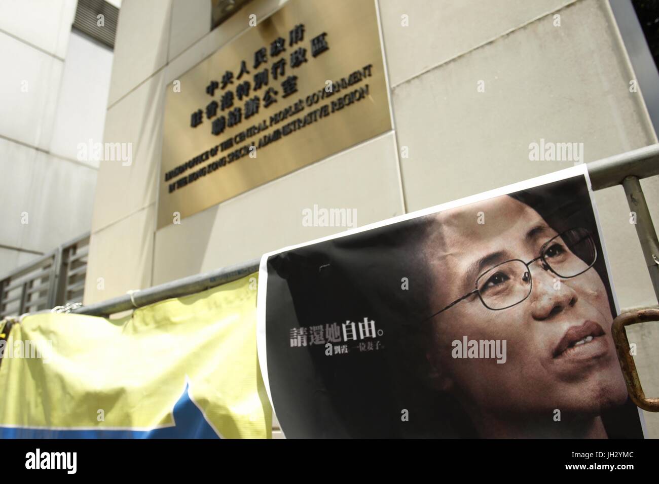 Hong Kong, Chine. Le 13 juillet, 2017. Une affiche-image de LIU XIA, l'épouse du dissident chinois, prisonnier politique et la lauréate du Prix Nobel de la paix LIU XIAO BO est affiché sur la barricade à l'extérieur du bureau de liaison du gouvernement populaire dans la Région administrative spéciale. Le caractère chinois sur l'affiche se lit : MERCI DE LUI RENDRE LA LIBERTÉ. Les citoyens de Hong Kong sont mise en scène quatrième jour sit-in pour LIU XIAO BO exigeant Lius publication immédiate que sa vie se joue sur le fil en raison d'un cancer terminal. Juillet 13, 2017.Hong Kong.ZUMA/Liau Chung Ren : Crédit Liau Chung Ren/ZUMA/Alamy Fil Live News Banque D'Images