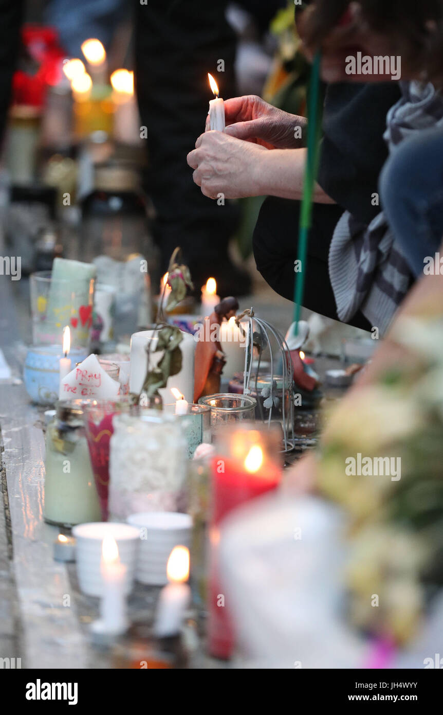 Bougies à la place des gens le mur commémoratif sur Bramley Road, Londres, comme ils participent à une veillée pour marquer quatre semaines depuis la tour de Grenfell incendie. Banque D'Images