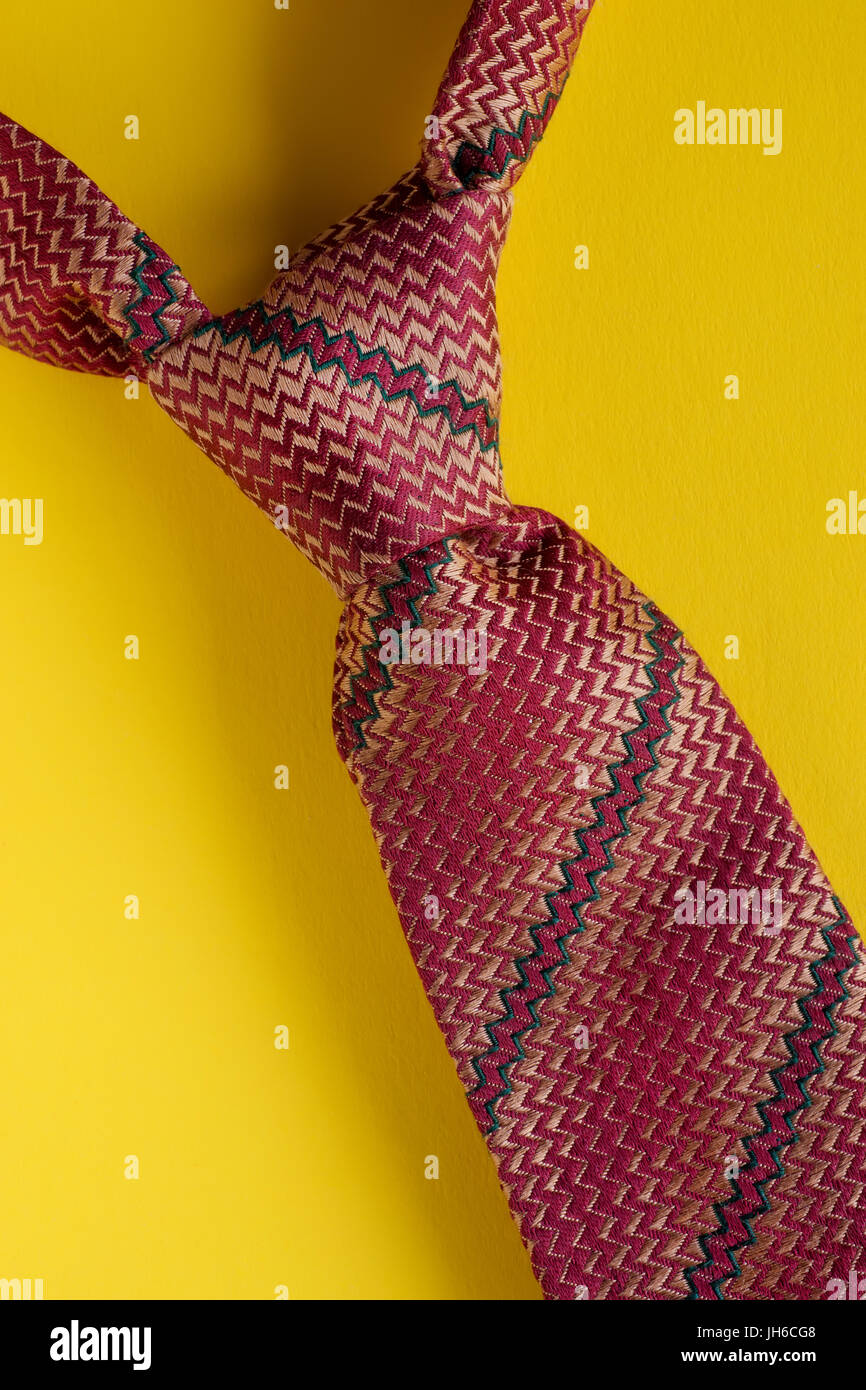 Nœud de cravate rayée marron classique close up sur fond jaune. Concept style homme Banque D'Images