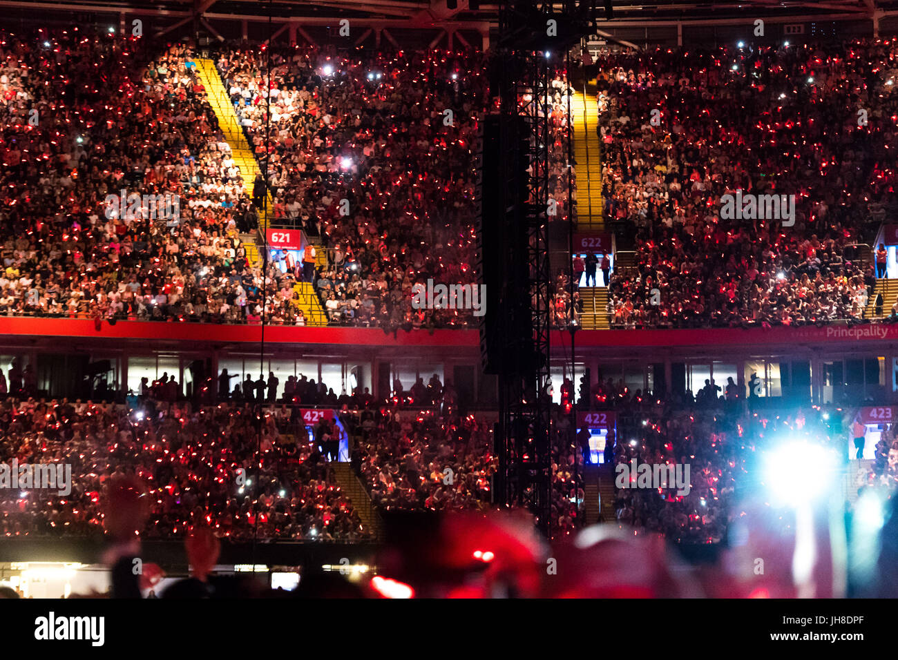 Fans dans la foule illuminée par leur lumière-up watch bracelets Coldplay effectuer à la Principauté Stadium de Cardiff le 11 juillet 2017. Banque D'Images