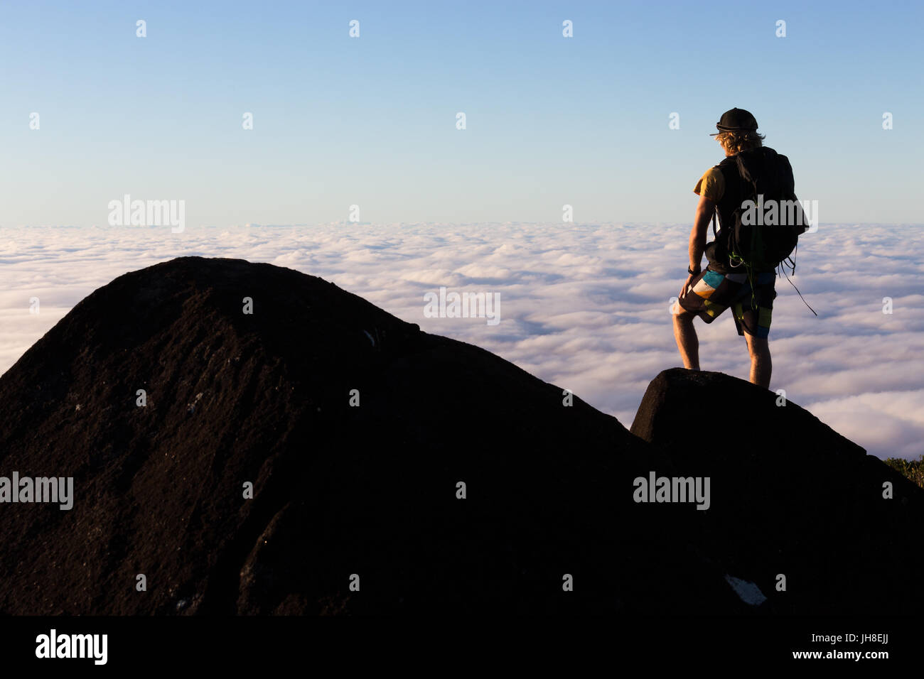 L'alpiniste donne sur une vue au-dessus du sommet des nuages à partir du sommet d'une montagne en Australie. Banque D'Images