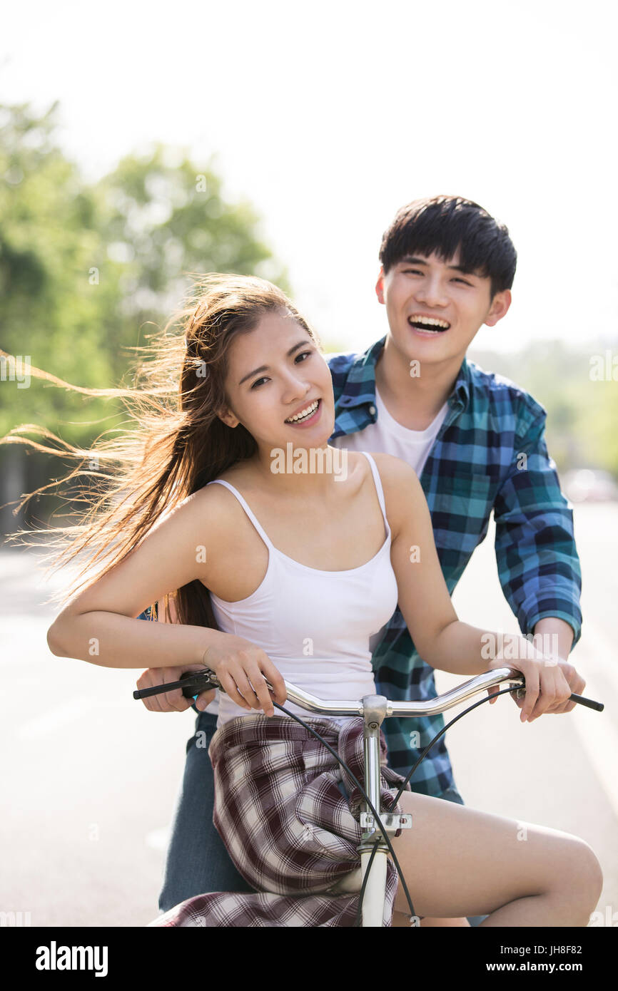 Jeune couple riding bikes outdoors Banque D'Images