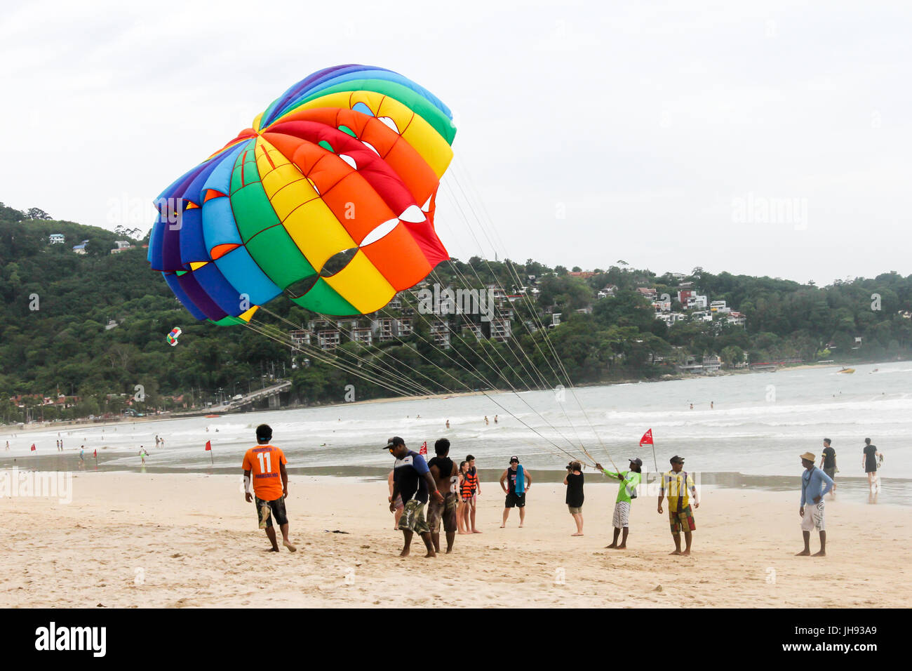 Les touristes et les manutentionnaires de parachute ascensionnel sur la plage de Patong, Phuket, Thailand Banque D'Images