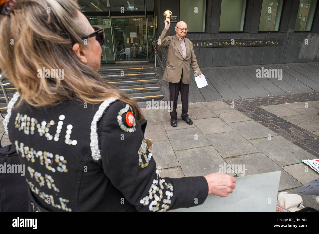 Londres, Royaume-Uni. 13 juillet 2017. Partisans, y compris une femme dans un manteau nacré avec message "maisons du Conseil de personnes non lucratif' écouter hors cour des magistrats d'Highbury Corner Rév. Paul Nicolson de contribuables contre la pauvreté, assigné à comparaître à la suite de son refus de payer les impôts en solidarité avec tout le monde au Royaume-Uni la souffrance psychique ou physique en raison de l'insuffisance des revenus et de la dette de bell sa sonnerie à la fin de son discours. Il a parlé sur la pression des restrictions budgétaires sur les pauvres qui ont désespérément besoin de payer pour la nourriture, le carburant, les vêtements et le transport et nous a rappelé le principe éthique oublié ' Banque D'Images