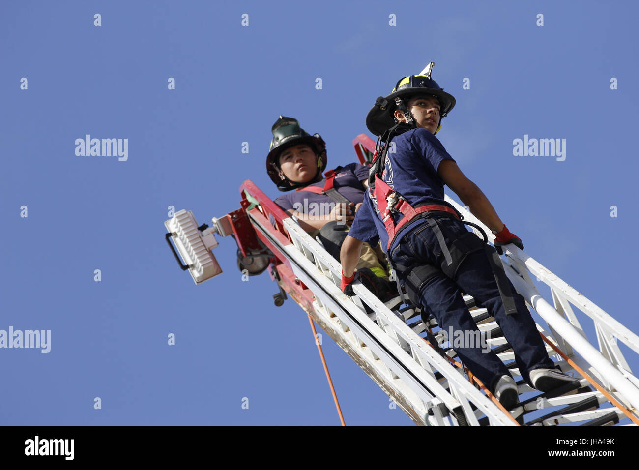 13 juillet 2017 - San Diego, CA, USA - San Diego Fire-Rescue Ryan cadets Pablo, haut, conseille camion échelle aérienne climber Elvis Aguirre, 15 ans, de citronniers qu'il monte jusqu'à la 105-pied de l'échelle.Le San Diego Fire-Rescue Ministère a organisé un premier pompier Junior Camp au centre de formation off Fire-Rescue Kincaid Road près de l'extrémité ouest de Lindbergh Field. Les garçons et filles âgés de 10''"16 ont été invités à participer à cette semaine de camp et apprendrez à utiliser des flexibles et des échelles, de recherche et de sauvetage contre l'incendie premiers soins de base et des compétences. Il y a un total de 100 campeurs ; à environ Banque D'Images