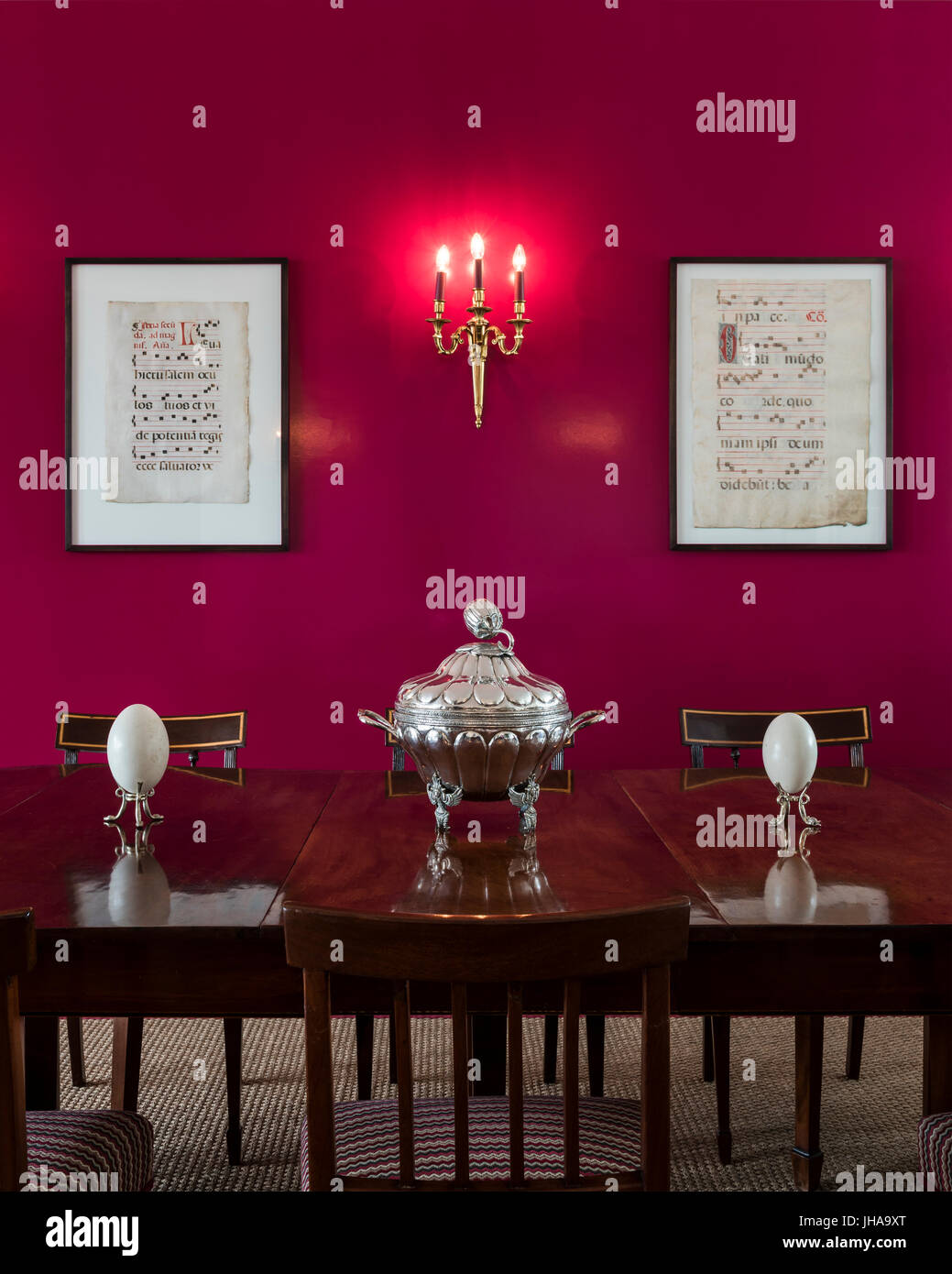 Ornements sur table à manger en bois avec mur rouge Banque D'Images