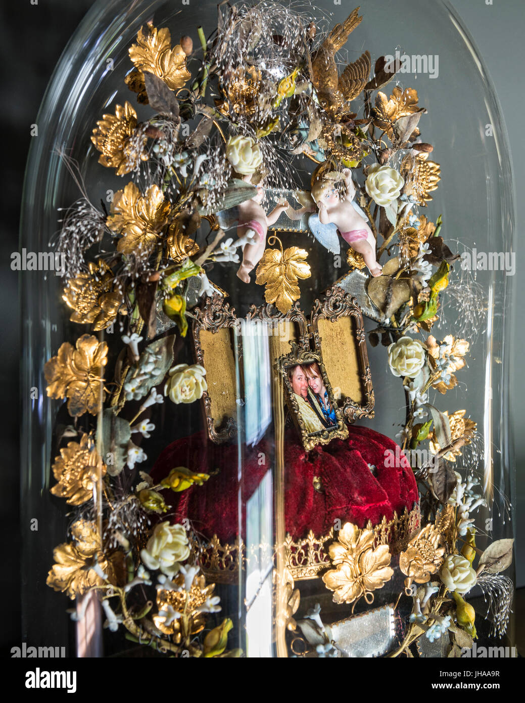 Photo sur coussin avec fleurs sculptées sous bell jar Banque D'Images