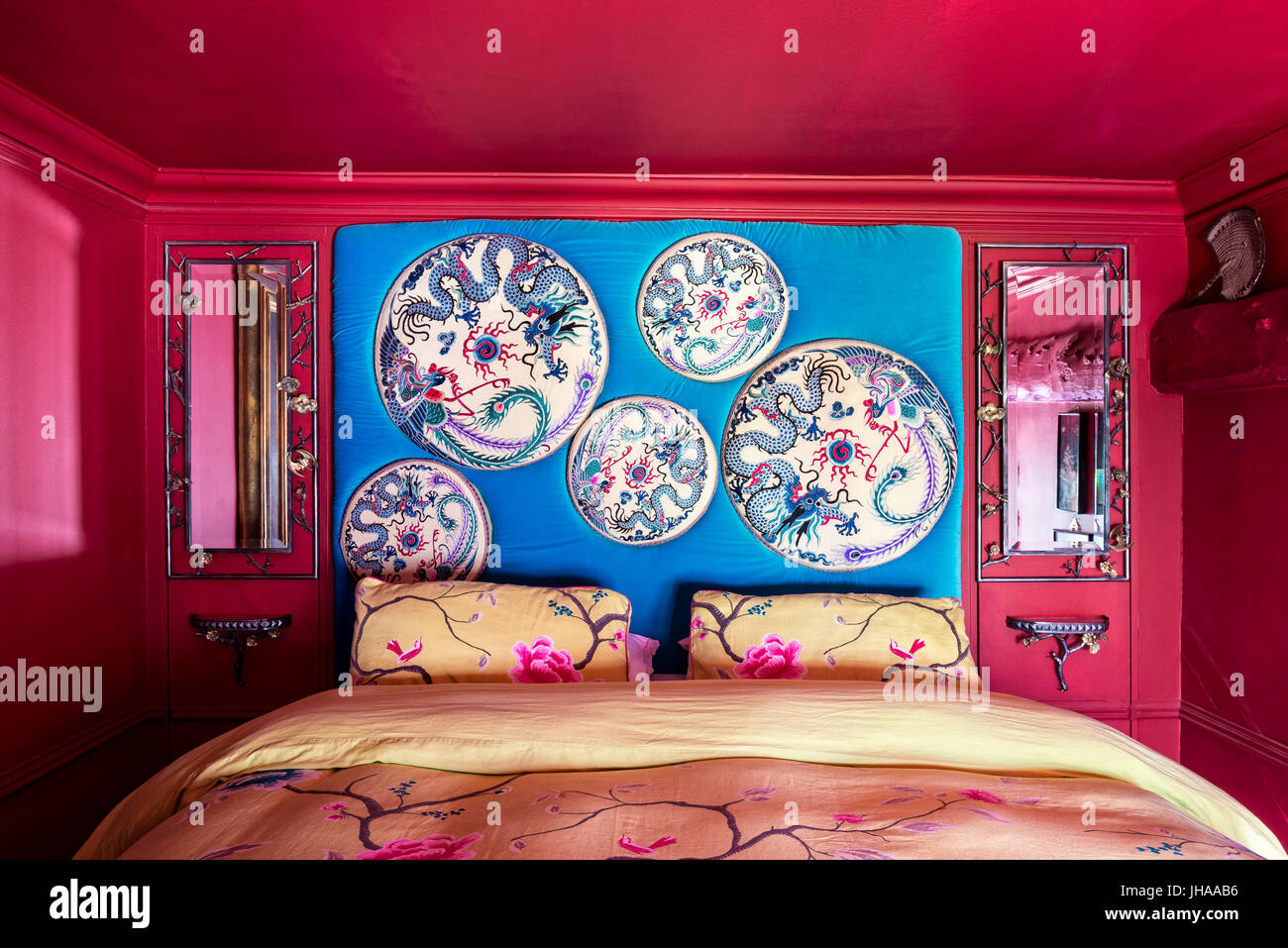 Peinture bleu au-dessus de lit dans la chambre rouge Banque D'Images