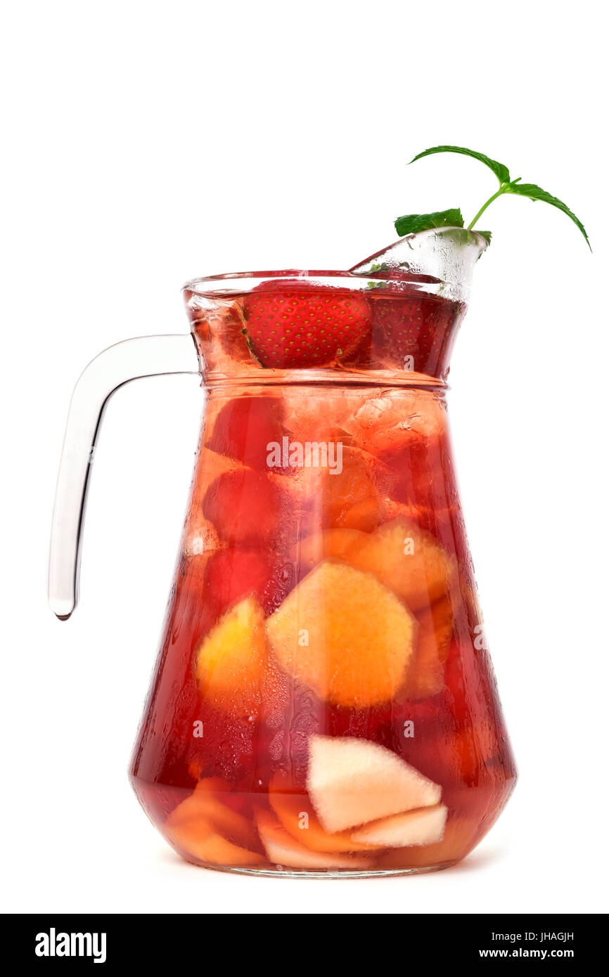 Un pichet de verre avec sangria espagnol typique, avec quelques morceaux de fruits frais sur un fond blanc Banque D'Images