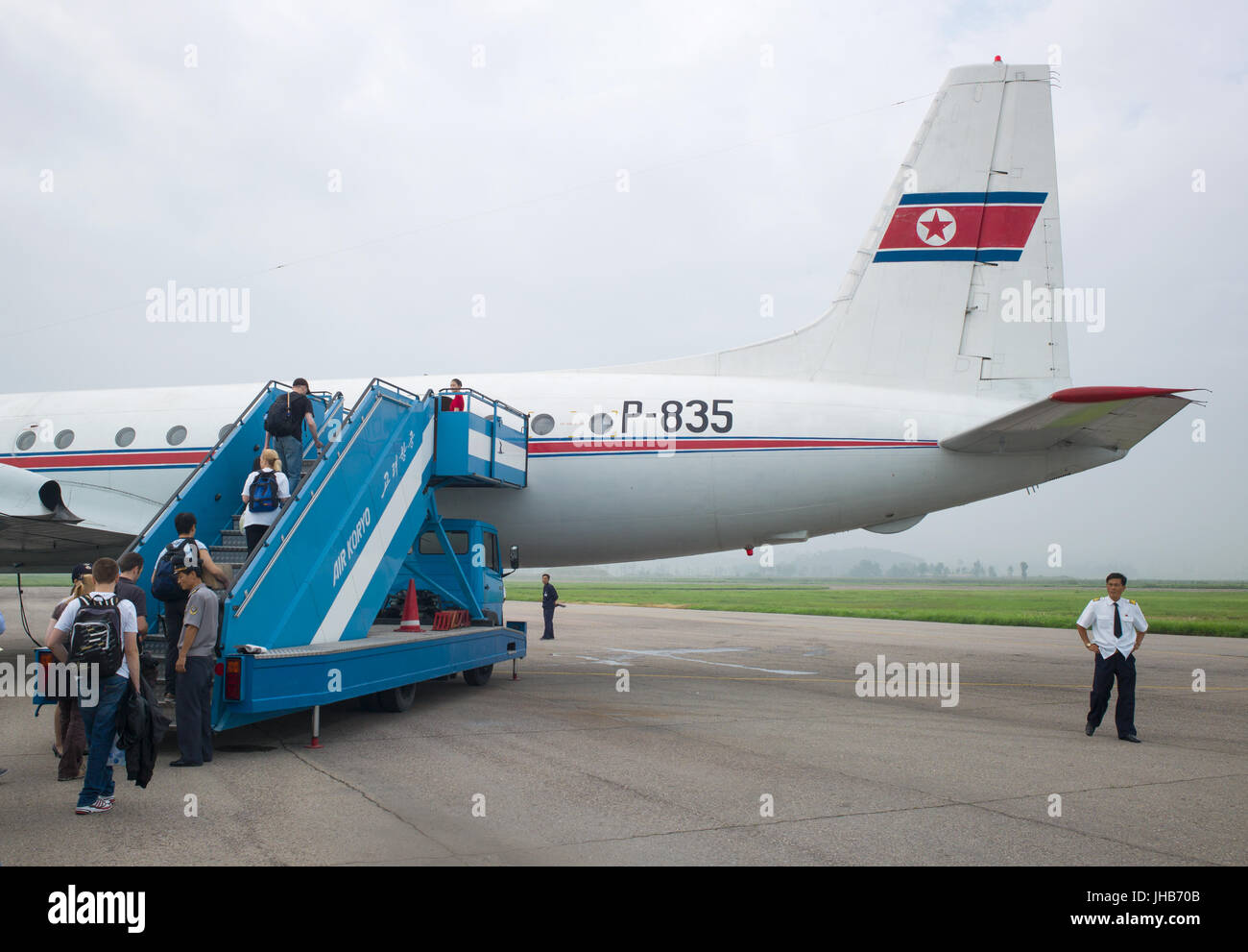 Les passagers d'Air Koryo Iliouchine Il-18D P-835 d'Air Koryo étapes arrière via l'Aéroport International de Sunan à Pyongyang. Corée du Nord / Corée du Nord Banque D'Images