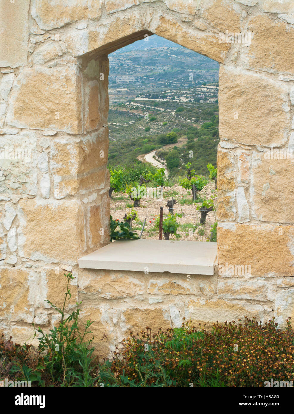 Vue sur vignoble montagne chypriote par le trou dans le mur de pierre Banque D'Images